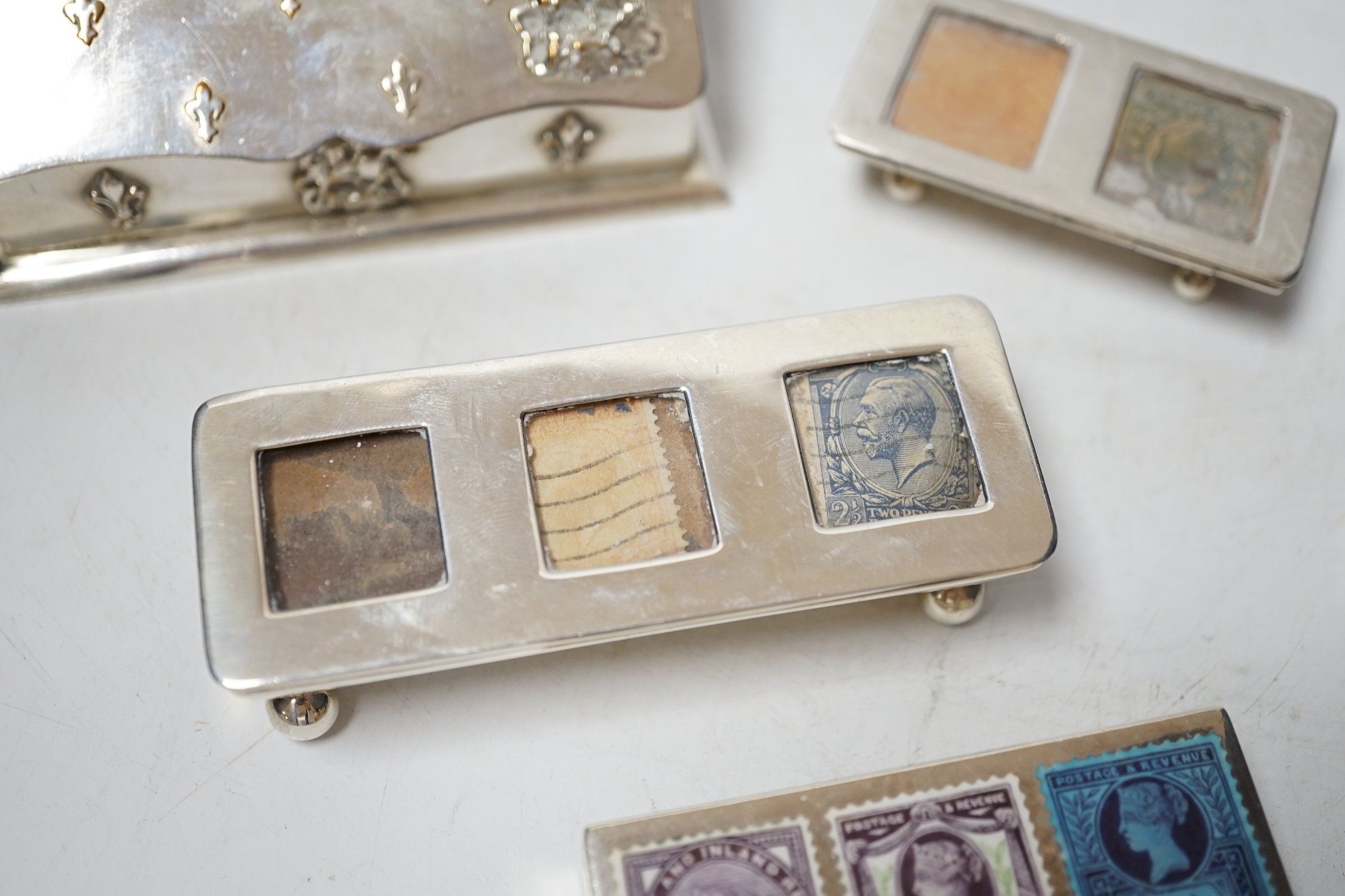 Four assorted late 19th/early 20th century silver stamp boxes, including triple compartment, one with enamelled 'stamps', largest 9cm and one plated stamp box.